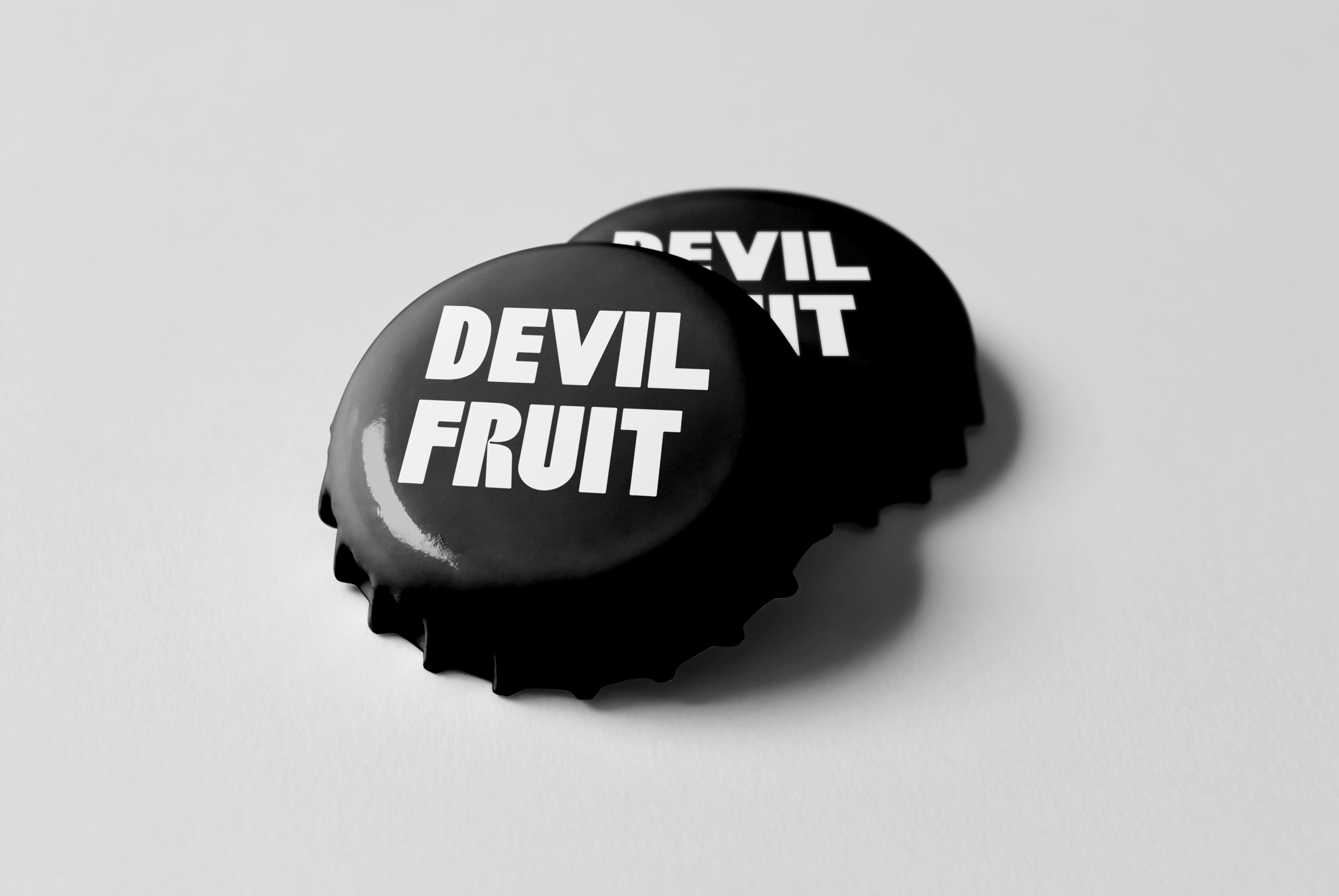 Two black Devil Fruit bottle caps with the wordmark in white
