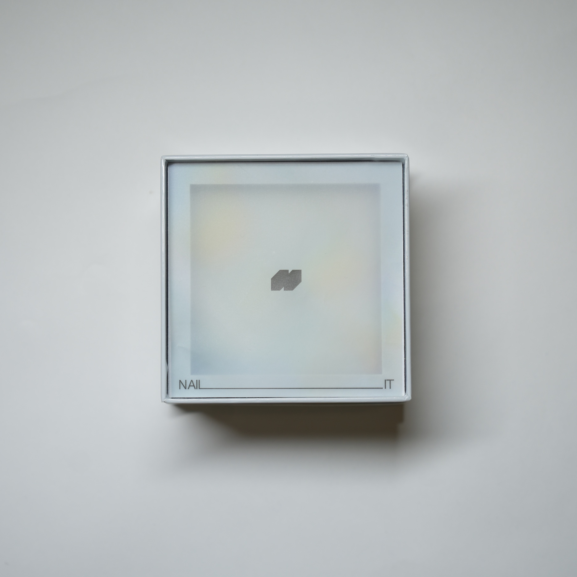 Top view of the primary NAILIT box with a translucent lid and extended wordmark
