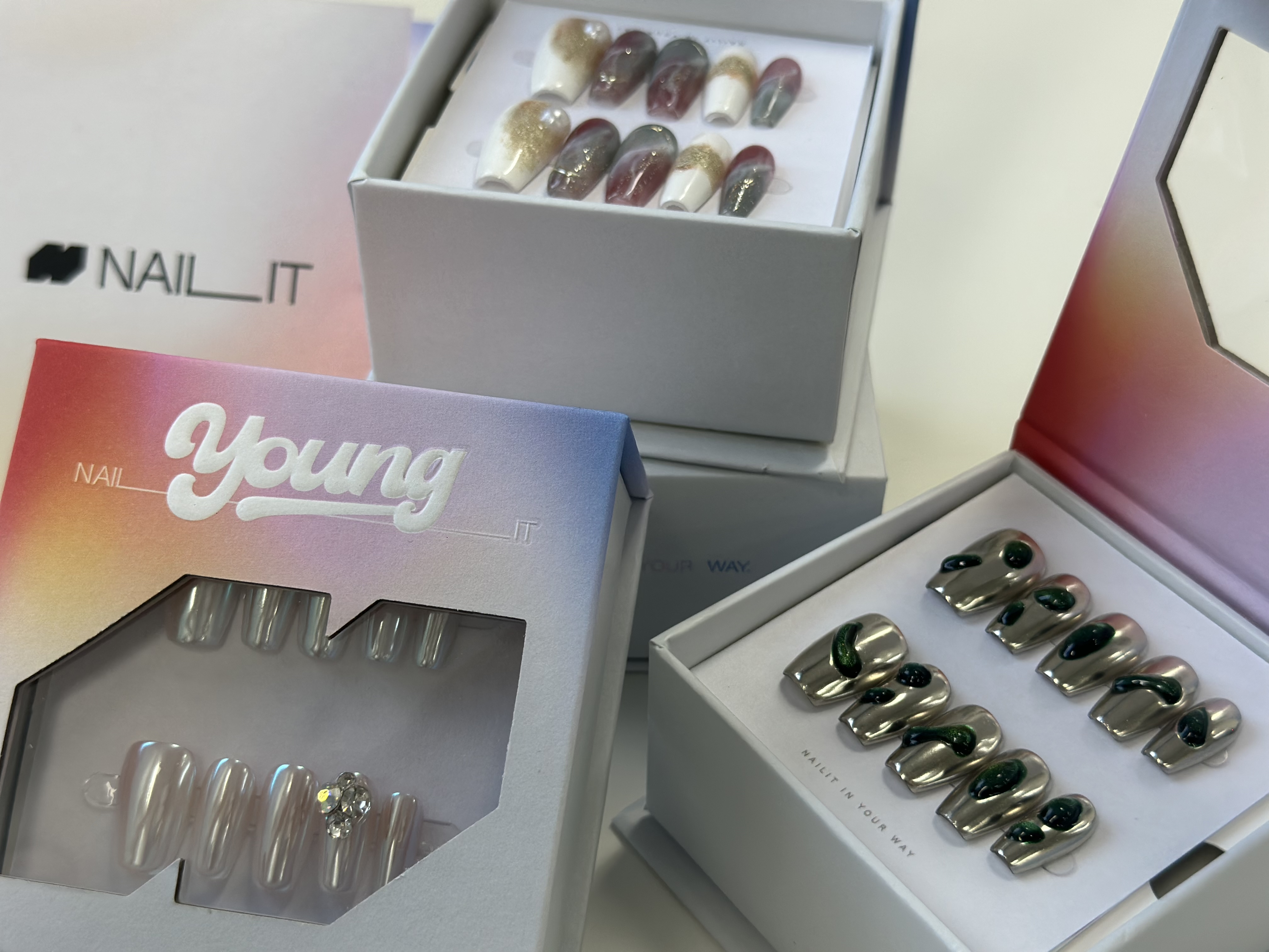NAILIT Young packaging with a die-cut NAILIT-symbol window revealing press-on nail sets